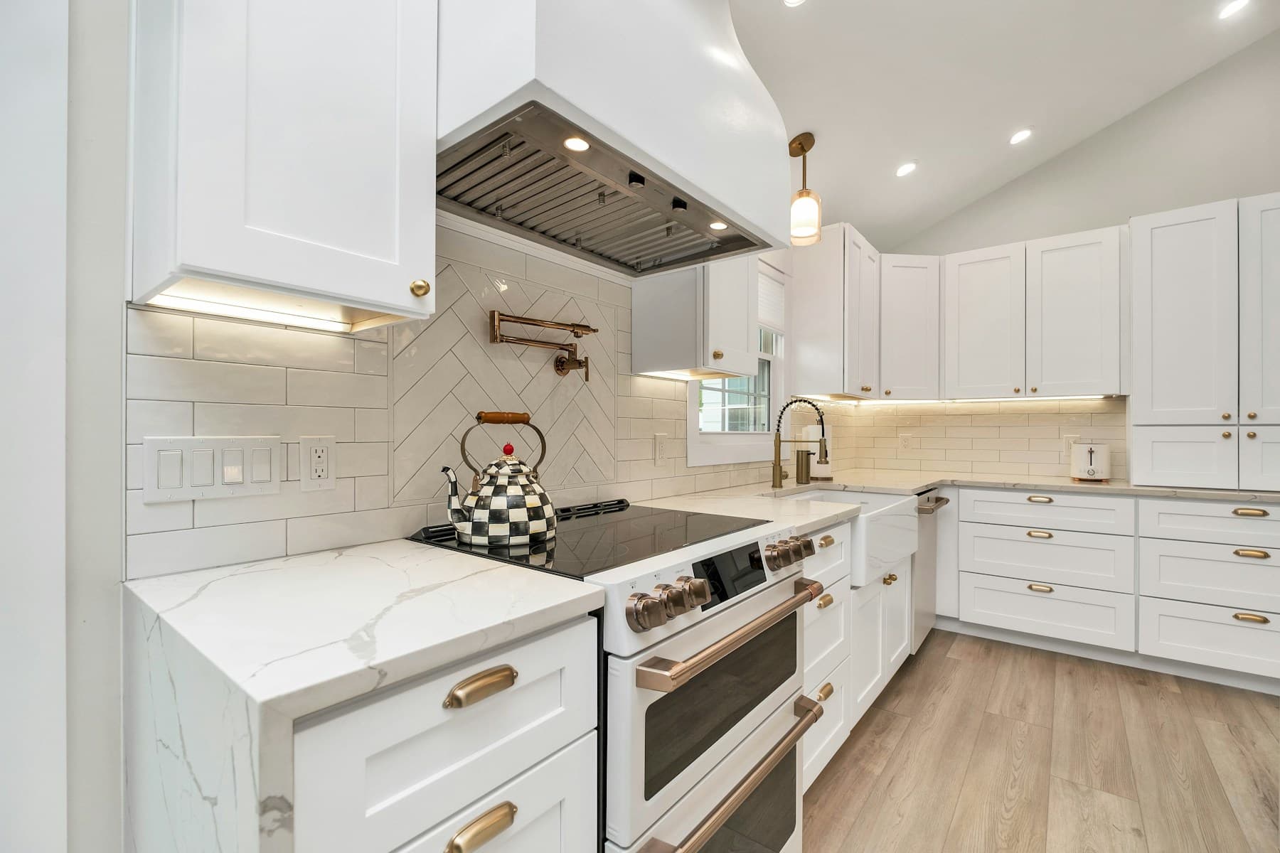 Kitchen with white shaker cabinets and a herringbone backsplash