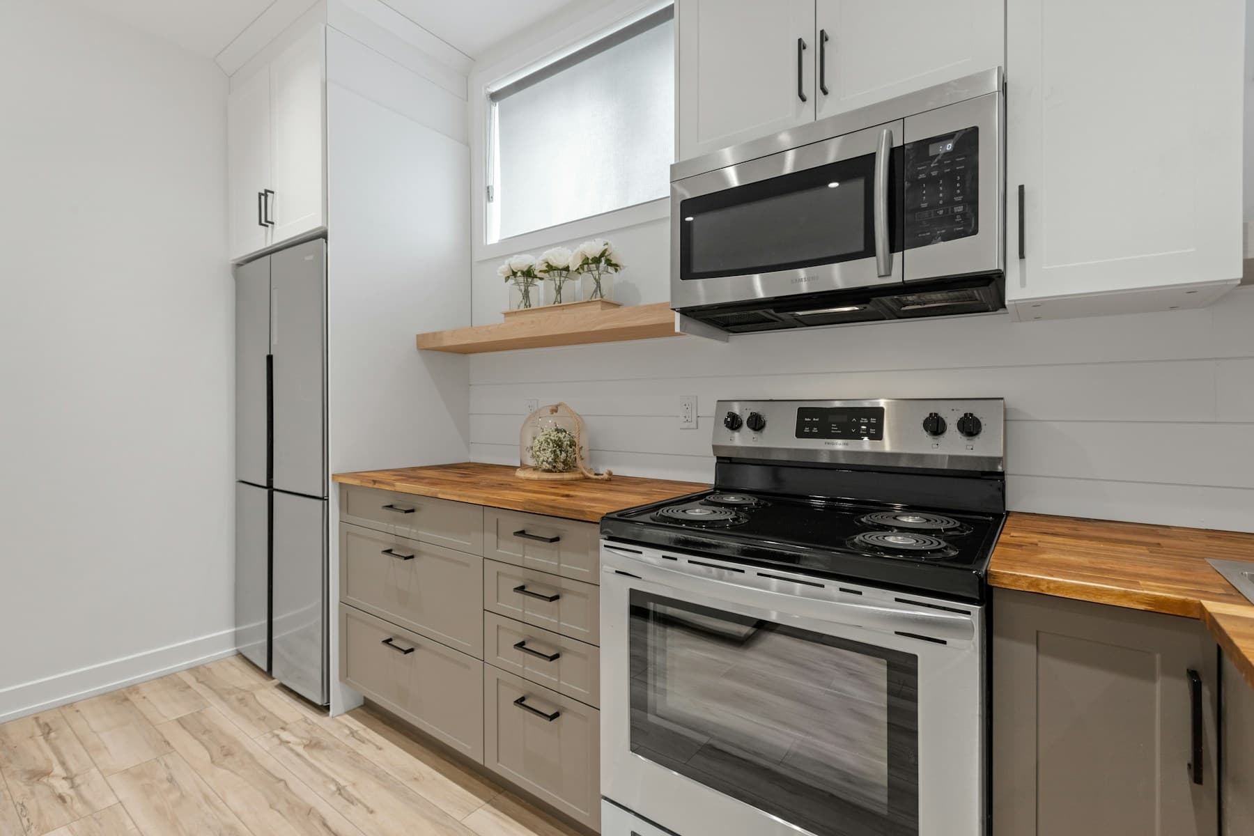 Kitchen with warm greige cabinets and butcher-block counters