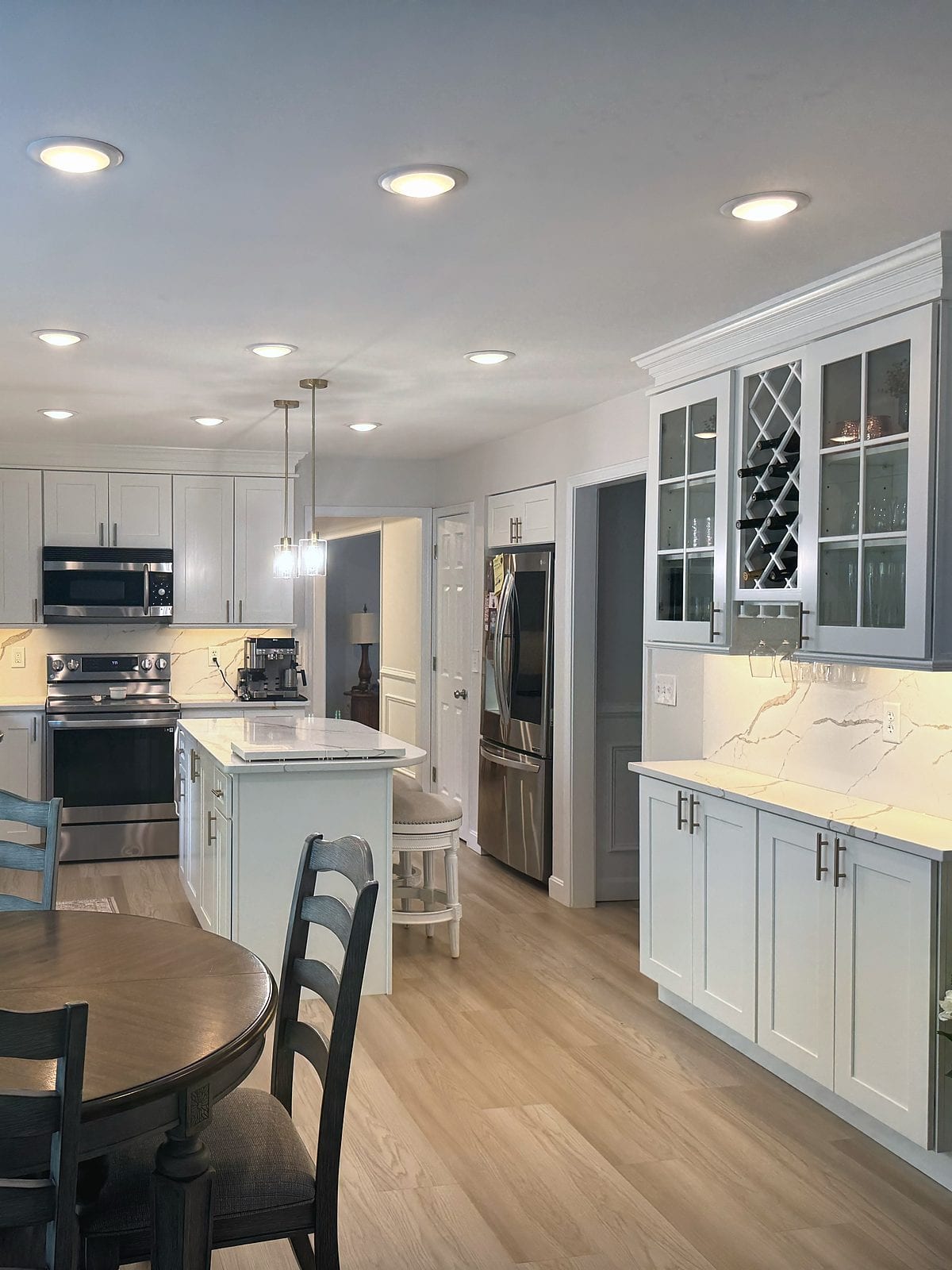 Finished white kitchen with an island and a glass-front storage cabinet